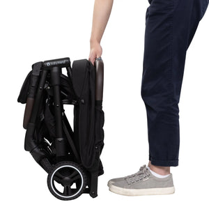 Side view of a person just finishing folding the Baby Trend Zenda Compact All-Terrain Stroller 