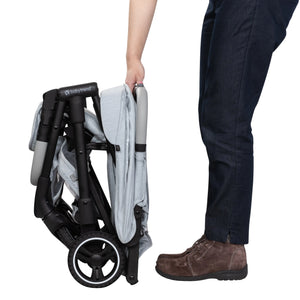A person just finished folding the Baby Trend Zenda Compact All-Terrain Stroller