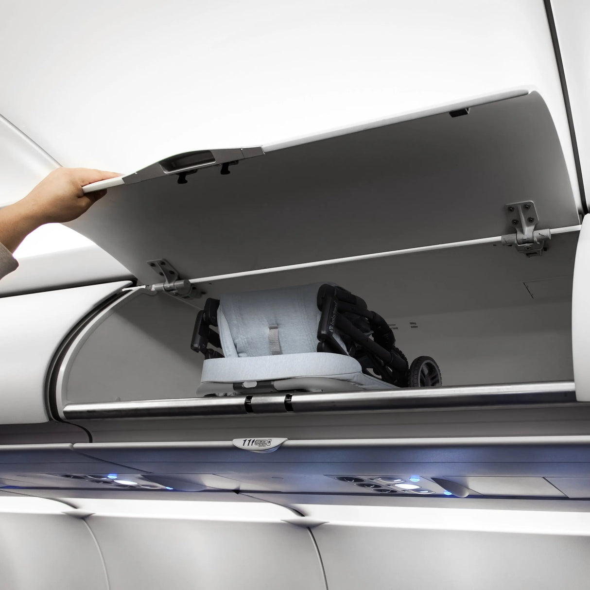 The Baby Trend Zenda Compact All-Terrain Stroller is folded and placed into the bin of an airplane