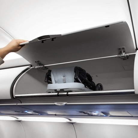 The Baby Trend Zenda Compact All-Terrain Stroller is folded and placed into the bin of an airplane