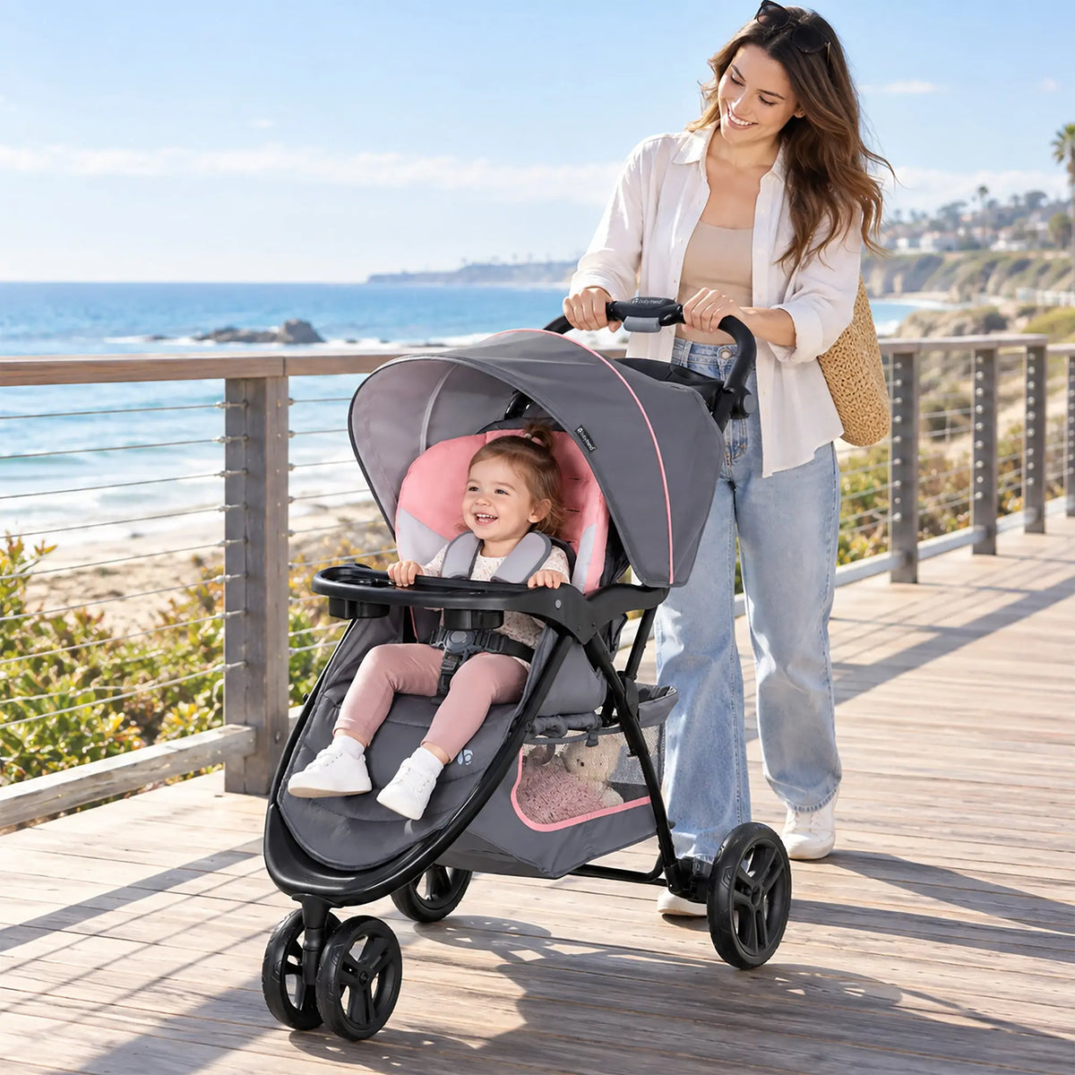 A mom is taking her child on a stroll along the beach with the Baby Trend EZ Ride Stroller