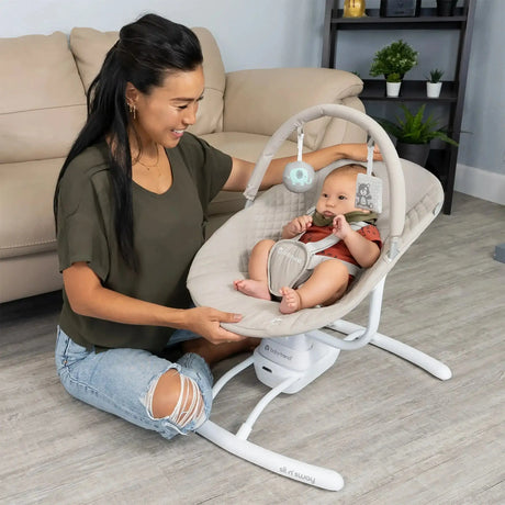 A mom is watching her child sit in the Baby Trend Sit N' Sway Portable Swing