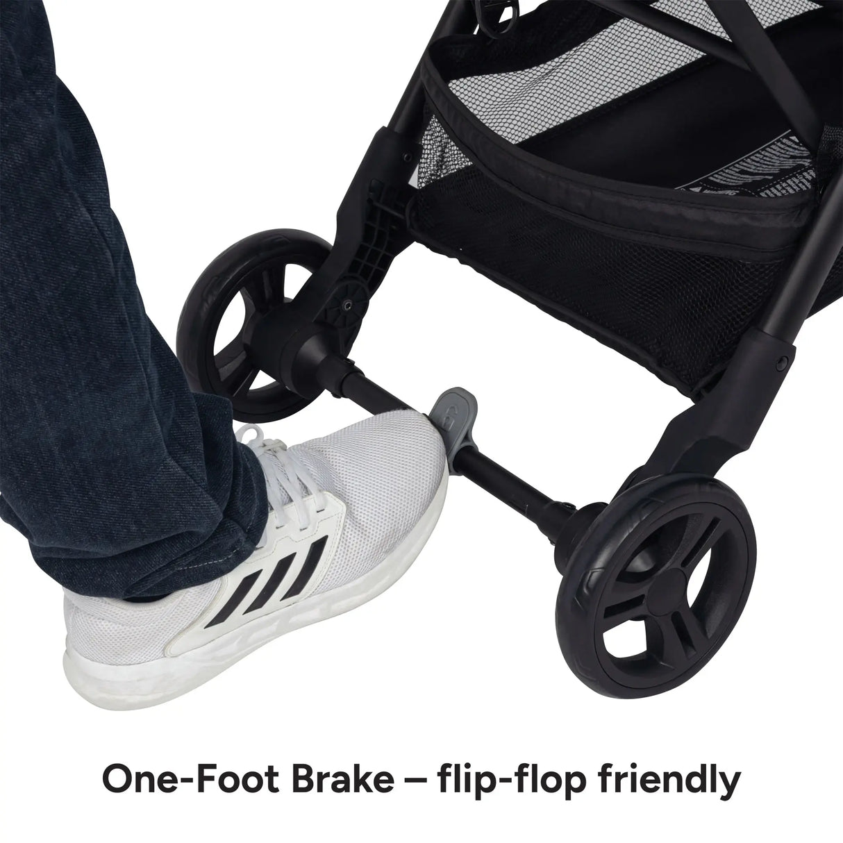 A foot is on the brake of the Baby Trend Sonar Compact Lightweight Stroller