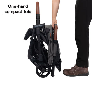 A hand is using the one hand compact fold of the Baby Trend Sonar Compact Lightweight Stroller