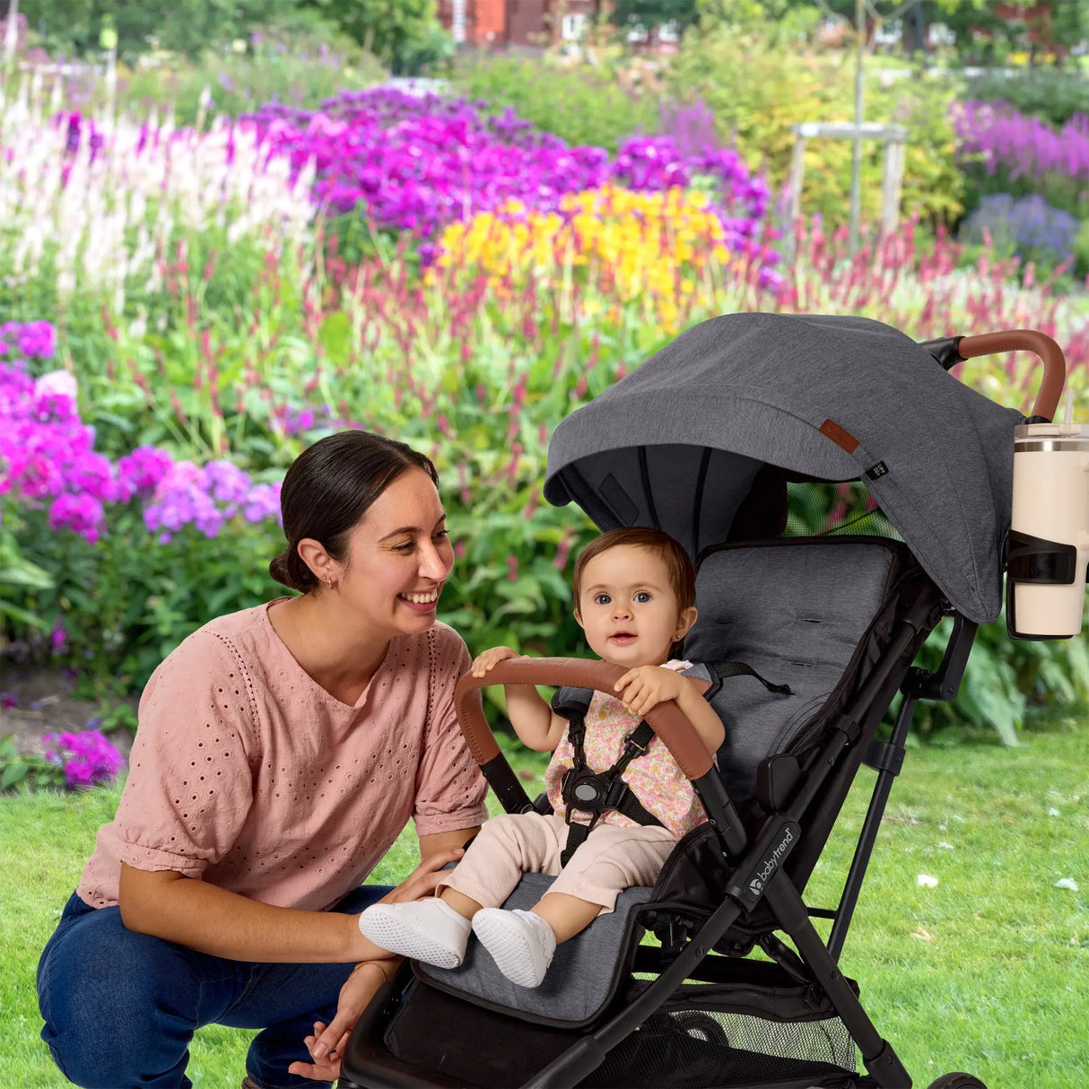 A mom is watching her child sitting in the Baby Trend Sonar Compact Lightweight Stroller