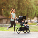 Load image into gallery viewer, Mom is jogging while pushing her child in the Baby Trend Expedition DLX Jogger
