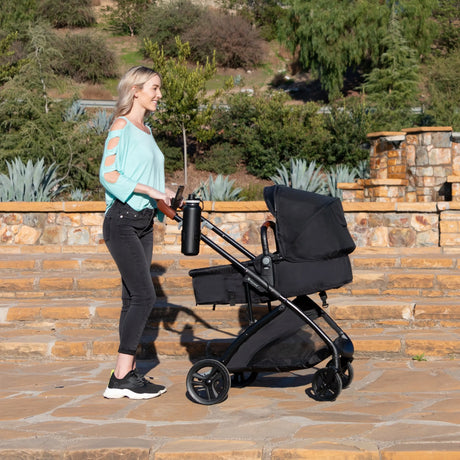 A mom is pushing her baby in the Baby Trend Passport Switch 6-in-1 Modular Stroller 
