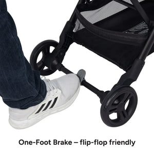 A foot is stepping on the one foot brake from the Baby Trend York Compact Stroller 