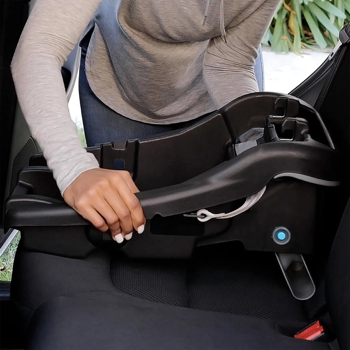A mom is installing the base of the Baby Trend EZ-Lift PRO Infant Car Seat into a vehicle