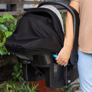 A person is carrying the Baby Trend EZ-Lift PRO Infant Car Seat using the ez side grip