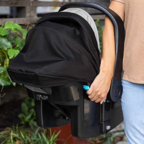 A person is carrying the Baby Trend EZ-Lift PRO Infant Car Seat using the ez side grip