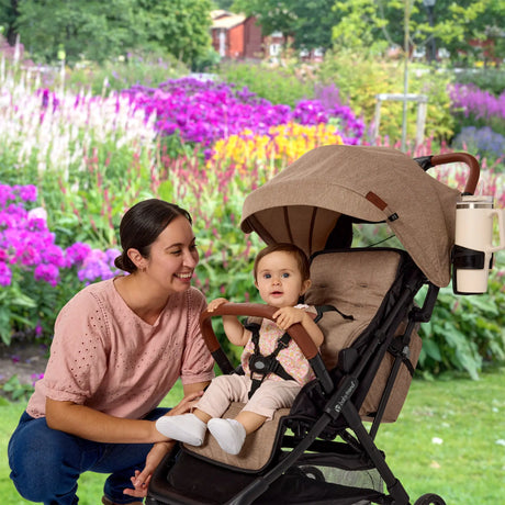 A mom is looking after her child sitting in the Baby Trend York Compact Stroller 