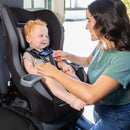 Load image into gallery viewer, A mom is placing the harness on her child sitting the Baby Trend Trooper Convertible Car Seat