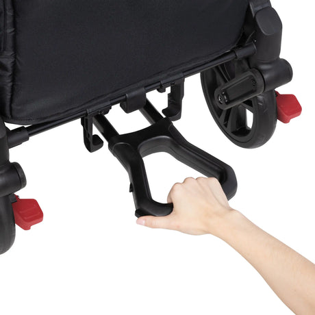 A hand is pulling out the pull handle from the Baby Trend Expedition 2-in-1 Stroller Wagon