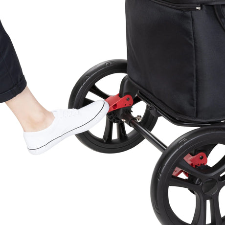 A person is pushing down on the brake of the Baby Trend Expedition 2-in-1 Stroller Wagon