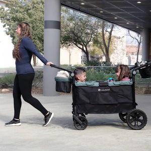 A mom is pulling her two children sitting in the Quest PLUS 3-in-1 Stroller Wagon