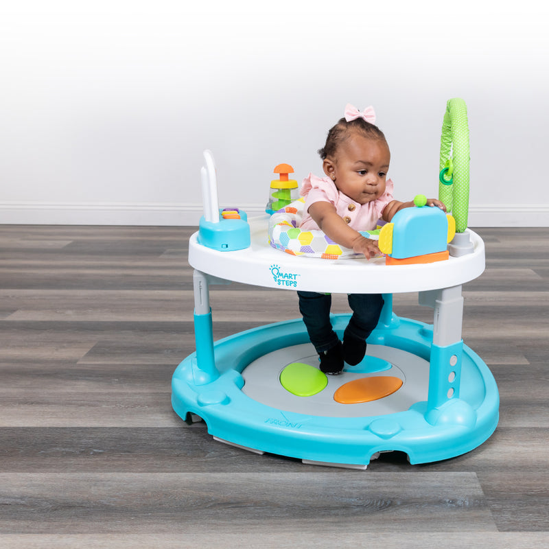 A child is playing in the Smart Steps Bounce N Dance activity center that can convert into a walker