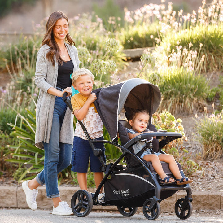 Baby Trend Sit N Stand 5-in-1 Shopper Stroller with mother and children