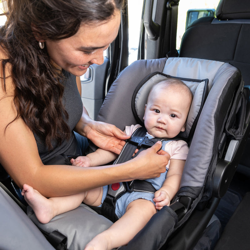 Mom is looking after her child in the Baby Trend EZ-Lift 35 PLUS Infant Car Seat