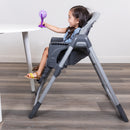 Load image into gallery viewer, Toddler girl sitting at the dining table on the Baby Trend Sit Right 2.0 3-in-1 High Chair