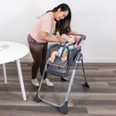 Load image into gallery viewer, Mom is feeding her child sitting on the Baby Trend Sit Right 2.0 3-in-1 High Chair