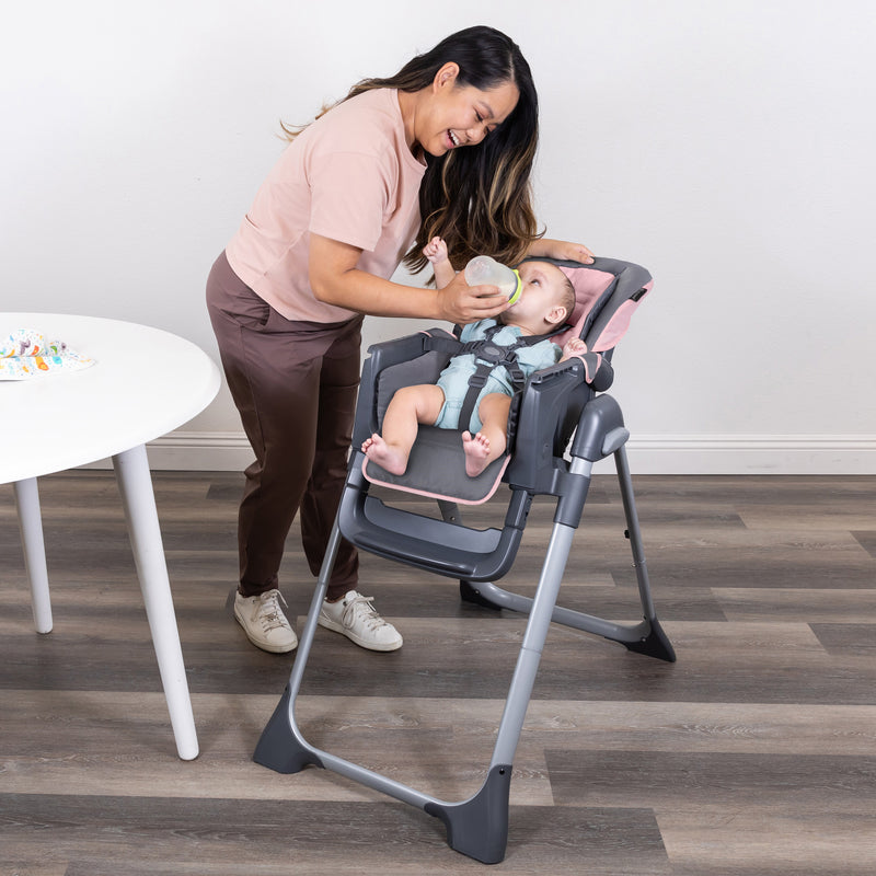 Mom is feeding her child sitting on the Baby Trend Sit Right 2.0 3-in-1 High Chair