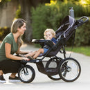 Load image into gallery viewer, Mom checking on her child outside with the Baby Trend XCEL-R8 PLUS Jogger Stroller with LED light