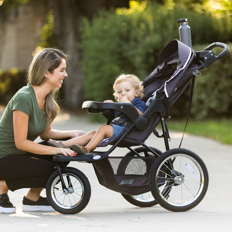Mom checking on her child outside with the Baby Trend XCEL-R8 PLUS Jogger Stroller with LED light