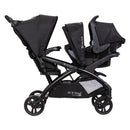 Load image into gallery viewer, Side view of the Baby Trend Sit N' Stand Double 2.0 Stroller with car seat in the front seat, infant car seat sold separately