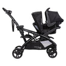 Load image into gallery viewer, Side view of the Baby Trend Sit N' Stand Double 2.0 Stroller with car seat in front seat and rear seat as jump seat