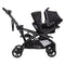 Side view of the Baby Trend Sit N' Stand Double 2.0 Stroller with car seat in front seat and rear seat as jump seat