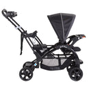 Load image into gallery viewer, Baby Trend Sit N' Stand Double Stroller side view with child front seat and includes bench and stand on platform in the rear