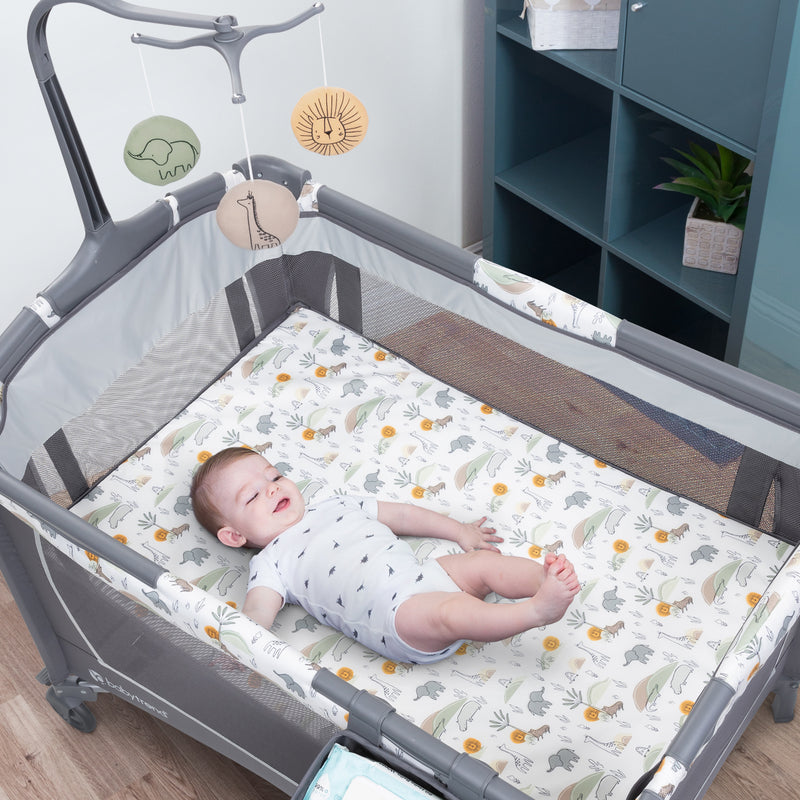 Baby playfully laying in the Baby Trend Nursery Center Playard