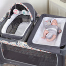 Load image into gallery viewer, Infant laying on the changing table for a change of the Baby Trend Lil’ Snooze Deluxe II Nursery Center Playard