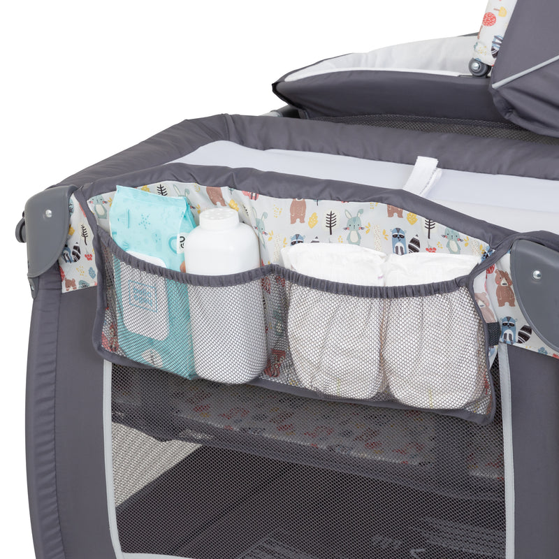 Side storage for diapers and changing supply on the Baby Trend Lil’ Snooze Deluxe II Nursery Center Playard