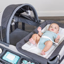 Load image into gallery viewer, Baby is laying on the changing table of the Baby Trend Deluxe II Nursery Center Playard