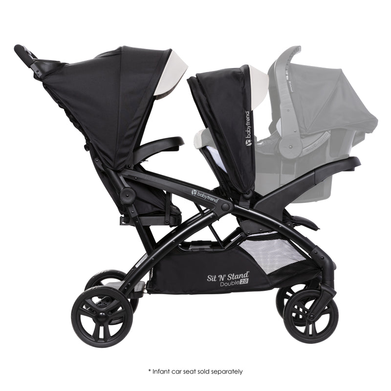 Side view of the Baby Trend Sit N' Stand Double 2.0 Stroller with infant car seat in front seat, infant car seat sold separately