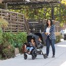 Load image into gallery viewer, A mom is pushing her two children in the Sit N' Stand Double 2.0 Stroller