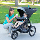 Load image into gallery viewer, Mother is using the child tray with her child in the Baby Trend Expedition Race Tec Plus Jogger Stroller