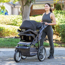 Load image into gallery viewer, Mom is outdoor pushing the Baby Trend Expedition Jogger Stroller Travel System