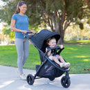 Load image into gallery viewer, Mother is strolling her daughter in the park with the MUV by Baby Trend Tango Pro Stroller Travel System