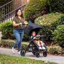 Load image into gallery viewer, Mother strolling with her child outdoor using the Baby Trend Sonar Seasons Stroller Travel System with EZ-Lift 35 Infant Car Seat