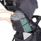 A parent is putting their bag in the cargo from the backseat of the Baby Trend Sonar Cargo 3-Wheel Stroller Travel System