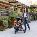 Load image into gallery viewer, Mom is strolling with her child outdoor using the Baby Trend Passport Seasons All-Terrain Stroller Travel System with EZ-Lift 35 PLUS Infant Car Seat