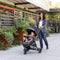 Mom is strolling with her child outdoor using the Baby Trend Passport Seasons All-Terrain Stroller Travel System with EZ-Lift 35 PLUS Infant Car Seat