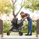 Load image into gallery viewer, Mom is checking on her infant in the Baby Trend EZ Ride Stroller Travel System with EZ-Lift 35 Infant Car Seat