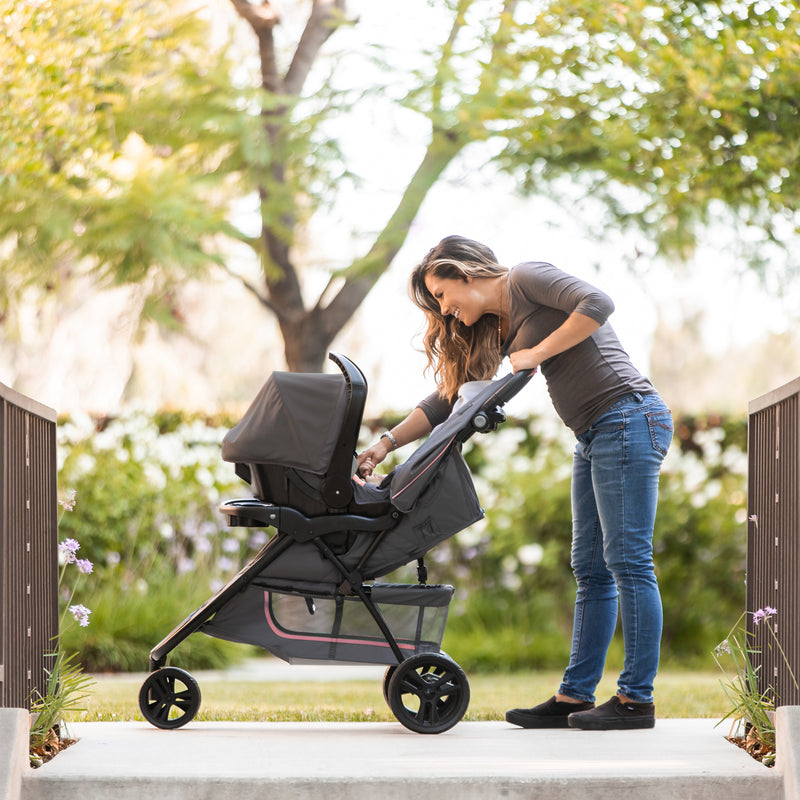 Mom is checking on her infant in the Baby Trend EZ Ride Stroller Travel System with EZ-Lift 35 Infant Car Seat