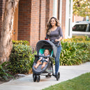 Load image into gallery viewer, Mom is pushing her child outdoor with the Baby Trend EZ Ride Stroller Travel System with EZ-Lift 35 Infant Car Seat