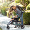 Mom looking over her child outdoor in the Baby Trend EZ Ride Stroller Travel System with EZ-Lift 35 Infant Car Seat