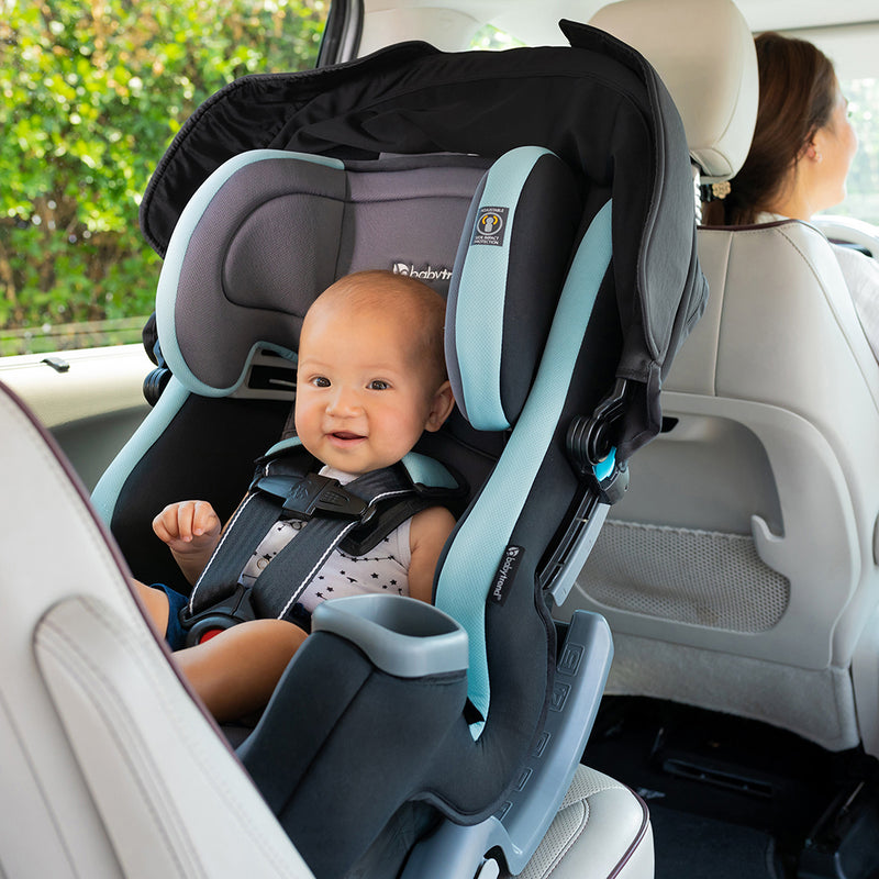 Baby in a rear seating position in the Baby Trend Cover Me 4-in-1 Convertible Car Seat of her mom's car